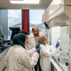 Konrad Krakowiak [background] and his research group demonstrate a machine in the lab.