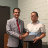 Heidar Malki, Senior Associate Dean of the Technology Division, presents Weihang Zhu, professor of Engineering Technology, with the Faculty Research Excellence Award.