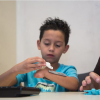 8-year-old Rafael tries on pieces of his gift - a new hand from UH students
