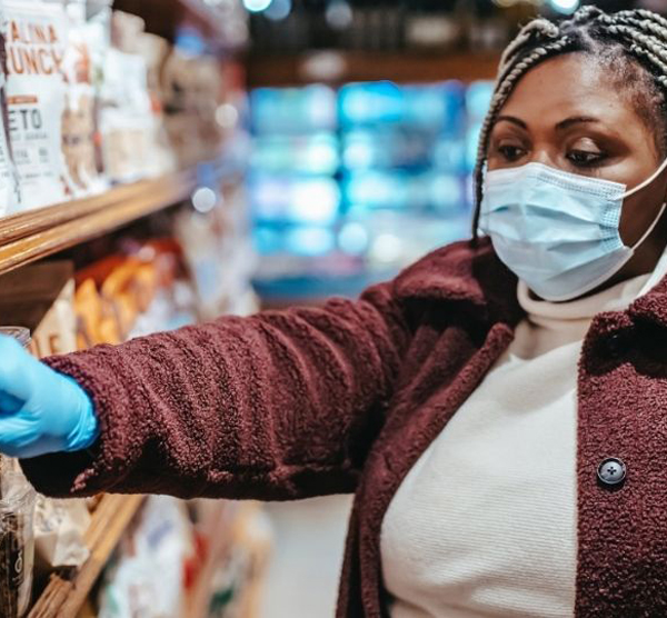 Person in mask and gloves shopping